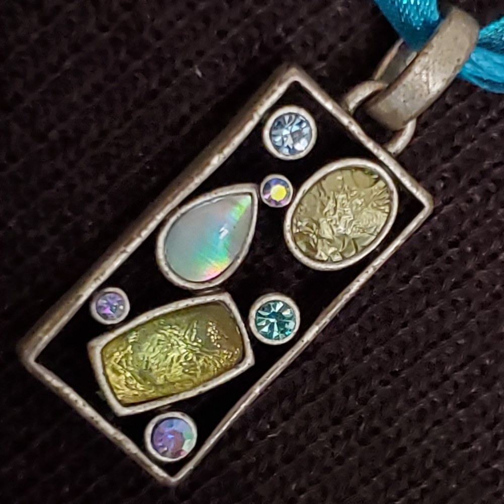 Silvertone geometric pendant with blue, green stones on turquoise cord necklace